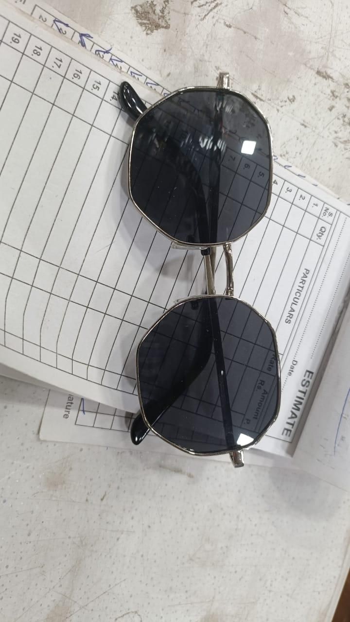 Unique octagon sunglasses with black lenses and stylish metal frame laid on an estimate paper